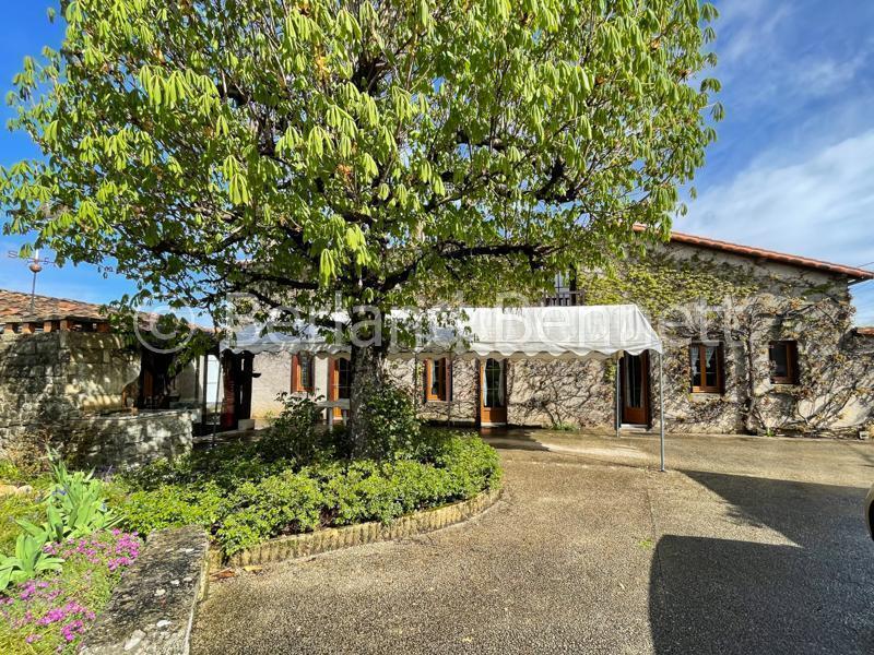 Maison en pierres avec garages et beau jardin